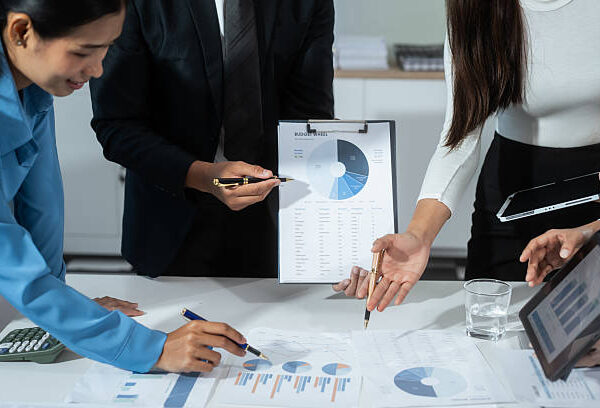 Entrepreneurs, marketers, managers, and financial analysts gather around the table to analyze data, present results, plan strategies, discuss efficiencies,grow their businesses through collaboration