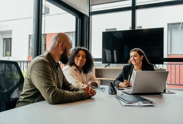 Couple talking to real estate agent in office