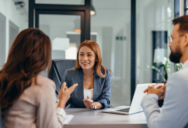 Shot of group of business persons in business meeting. Three entrepreneurs on meeting in board room. Corporate business team on meeting in modern office. Female manager discussing new project with her colleagues. Company owner on a meeting with two of her employees in her office. Three business professionals are engaged in a discussion at an office meeting, highlighting teamwork, professional attire, and a modern workplace environment.