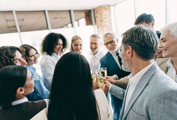 Diverse colleagues in a corporate office share a moment of celebration, showcasing unity, teamwork, and a positive workplace environment, ideal for business success.